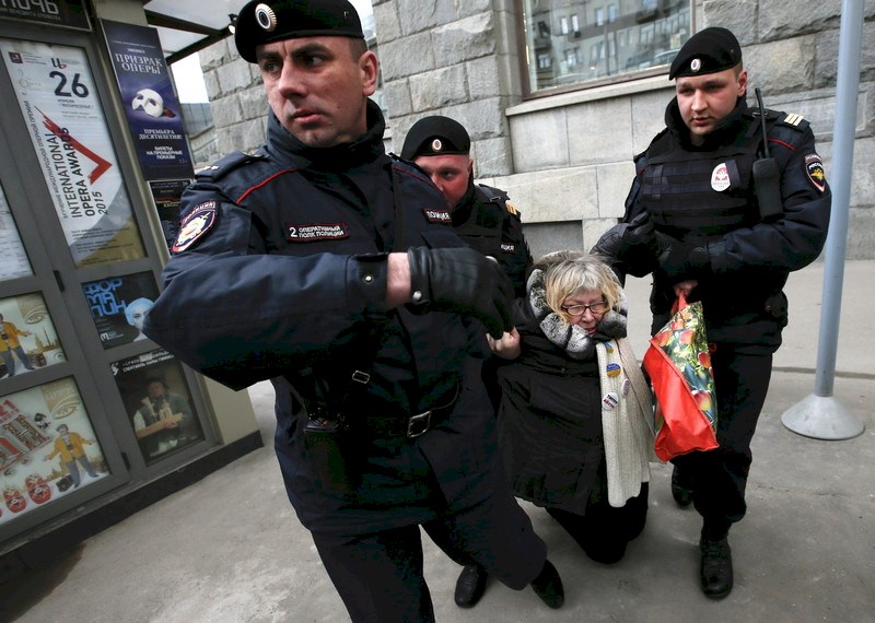 Rusya'da Putin karşıtı protestolar sırasında gözaltına alınan bir vatandaş. 